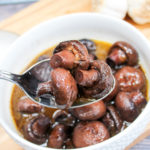 mushrooms in a white bowl with a spoon