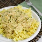 slow cooker italian chicken over noodles on a white plate