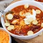 chili on a spoon with sour cream, cheese, and crackers