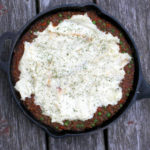 overhead picture of an iron skillet with lentil shepards pie topped with mashed potatoes