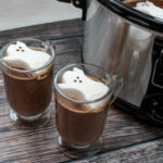 glasses filled with hot chocolate and topped with a ghost shaped marshmallow