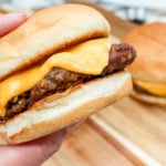 Cheeseburgers held in hand