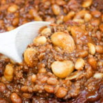 Baked beans in a pot with a wooden spoon