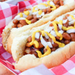 hot dog on the bun with beans and onion