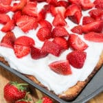 uncut photo of cake with whipped cream and strawberries