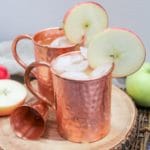 apple cider mule in a copper mug with an apple slice as a garnish