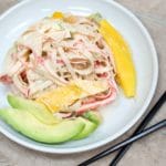 spicy kani salad on a plate with mango and avocado slices