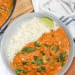 thai butternut squash curry in a bowl with rice next to a skillet with more curry