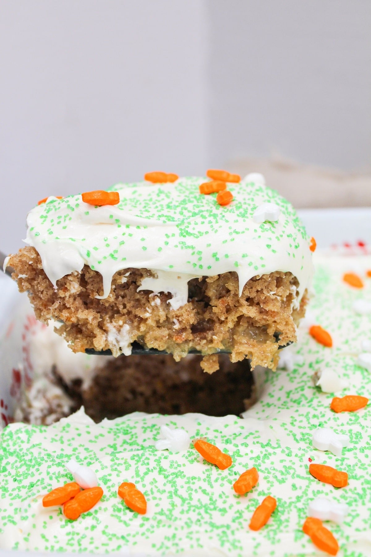 carrot cake poke cake lifted from the pan with a spatula