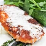 chicken costoletta on a plate with lemon sauce and asparagus.