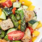 asparagus panzanella salad in a white bowl.