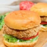 crispy chicken patty on a bun with shredded lettuce and sliced tomato.