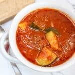zucchini and hamburger stew in a white bowl.