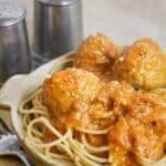 Meatballs cooked in a creamy tomato sauce over spaghetti.