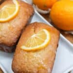 Mini pound cake loaves topped with a glaze and fresh lemon wedges.