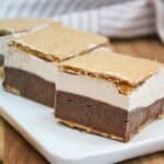 Chocolate and vanilla marshmallow ice cream layered between graham crackers on a white plate.